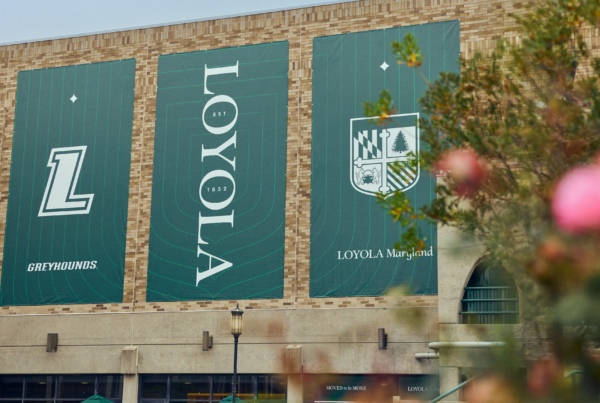 Loyola Maryland campus banners featuring the refreshed green brand identity