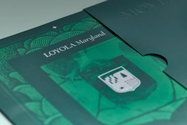 Loyola Maryland prospective student viewbook with embossed green shield cover